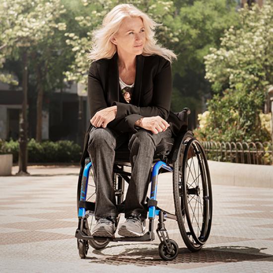 Lady sat in Kuschall Compact 2.0 wheelchair in black and blue
