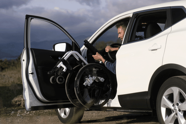 Man exiting car with Quickie Xenon² wheelchair with black and white hardware